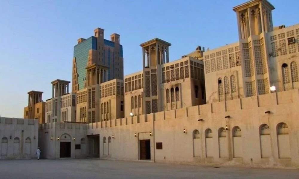 مبانٍ تقليدية بأبراج رياح على طول ممشى في منطقة تراثية