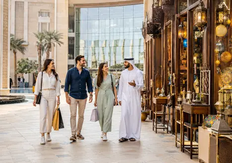 مسافرون يتصفّحون واجهات المتاجر خلال نزهة تسوّق في دبي